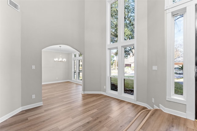 foyer with light hardwood / wood-style floors, a wealth of natural light, and an inviting chandelier