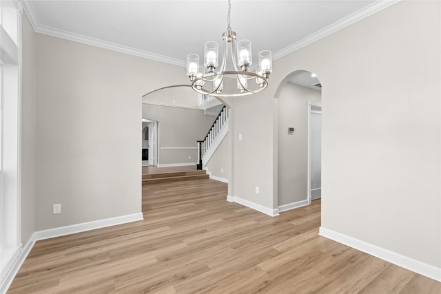 unfurnished dining area featuring ornamental molding, light hardwood / wood-style floors, and a notable chandelier