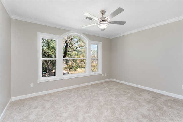 empty room featuring light carpet, ceiling fan, and crown molding