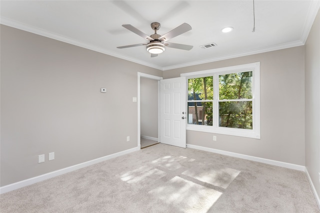 carpeted empty room with ceiling fan and crown molding