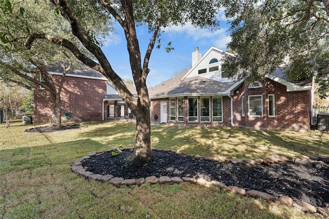 rear view of property with a lawn