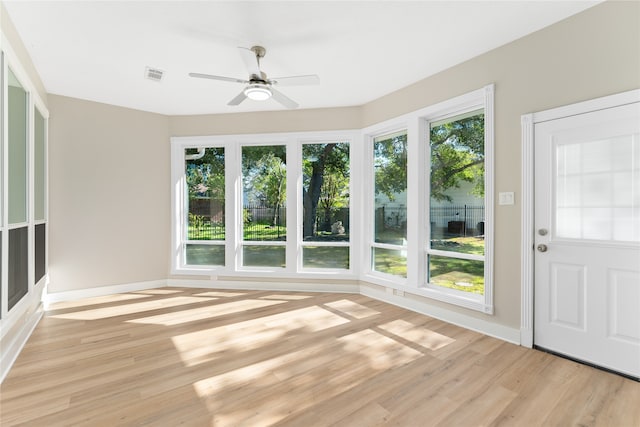 unfurnished sunroom featuring ceiling fan