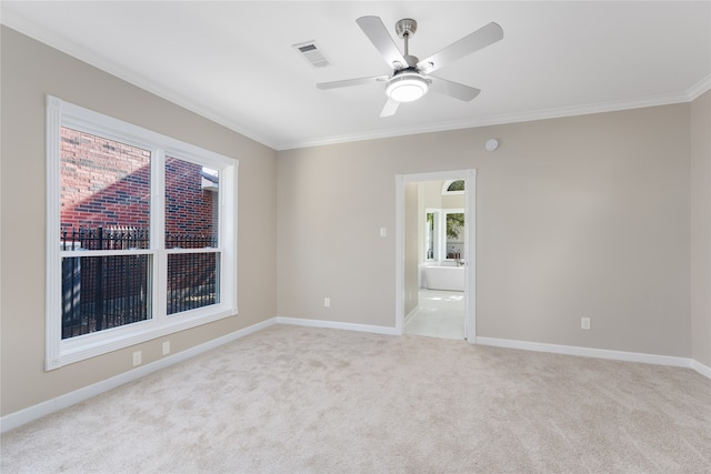 carpeted spare room featuring ceiling fan and crown molding