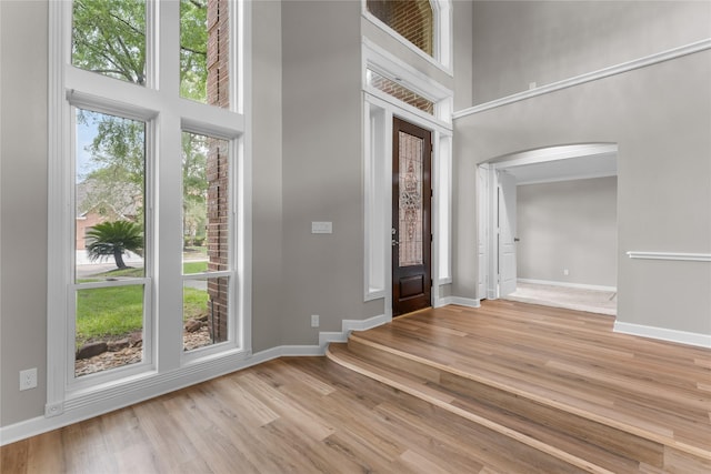 6627 Butler Oaks Ct, Spring, TX 77389 - entryway featuring arched walkways, a high ceiling, wood finished floors, and baseboards