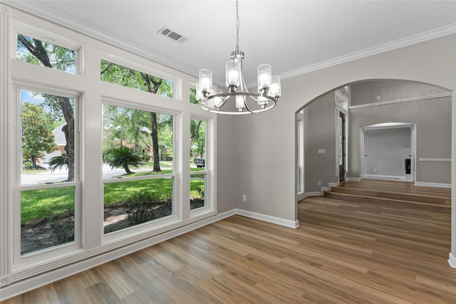 6627 Butler Oaks Ct, Spring, TX 77389 - unfurnished dining area with arched walkways, crown molding, a chandelier, baseboards, and wood finished floors