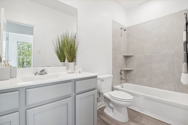 full bathroom featuring vanity, wood-type flooring, toilet, and tiled shower / bath