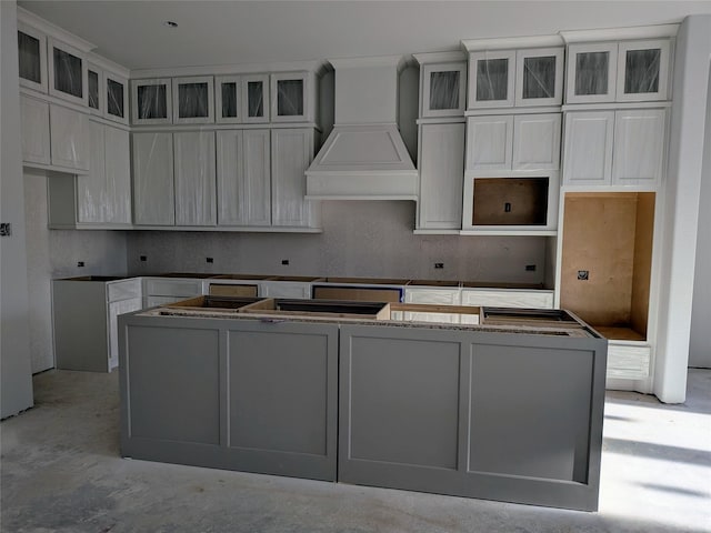 kitchen with premium range hood, white cabinets, and a center island