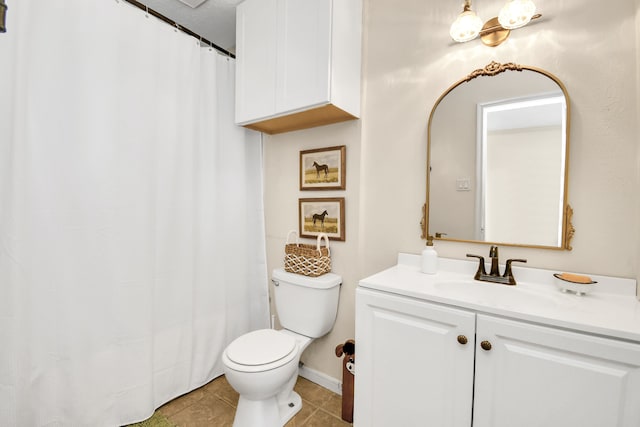 bathroom with tile patterned flooring, vanity, and toilet