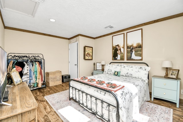 bedroom with crown molding, dark hardwood / wood-style flooring, and a textured ceiling