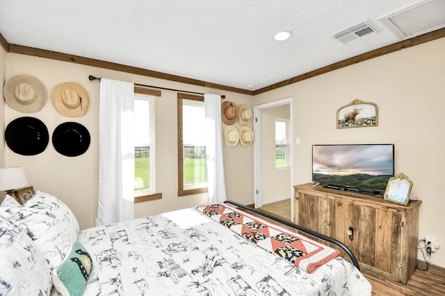 bedroom with light wood-type flooring and ornamental molding