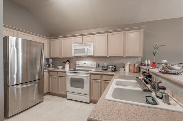 kitchen featuring sink, vaulted ceiling, white appliances, decorative backsplash, and light tile patterned floors