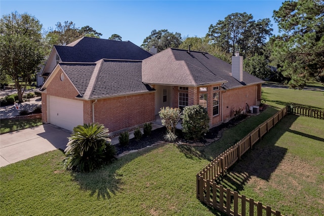 view of front of house with a front yard, a garage, and central AC unit