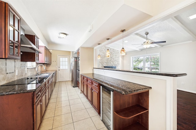 kitchen with black electric stovetop, plenty of natural light, hanging light fixtures, and wine cooler