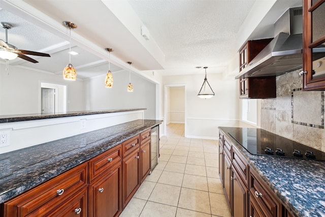 kitchen with wall chimney exhaust hood, light tile patterned floors, black electric cooktop, a textured ceiling, and decorative light fixtures