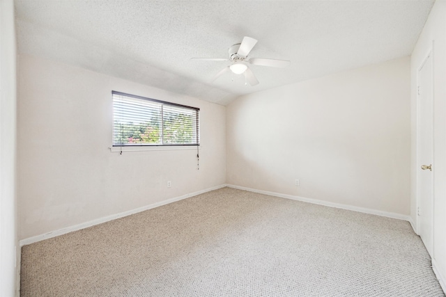 carpeted empty room featuring ceiling fan, lofted ceiling, and a textured ceiling