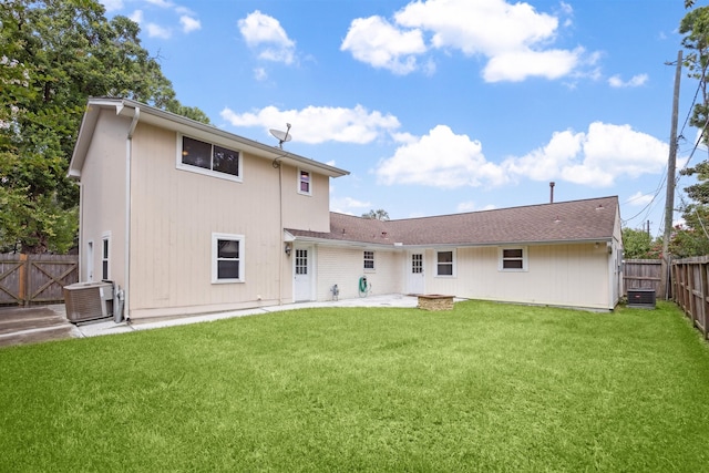 rear view of property featuring a yard and central air condition unit