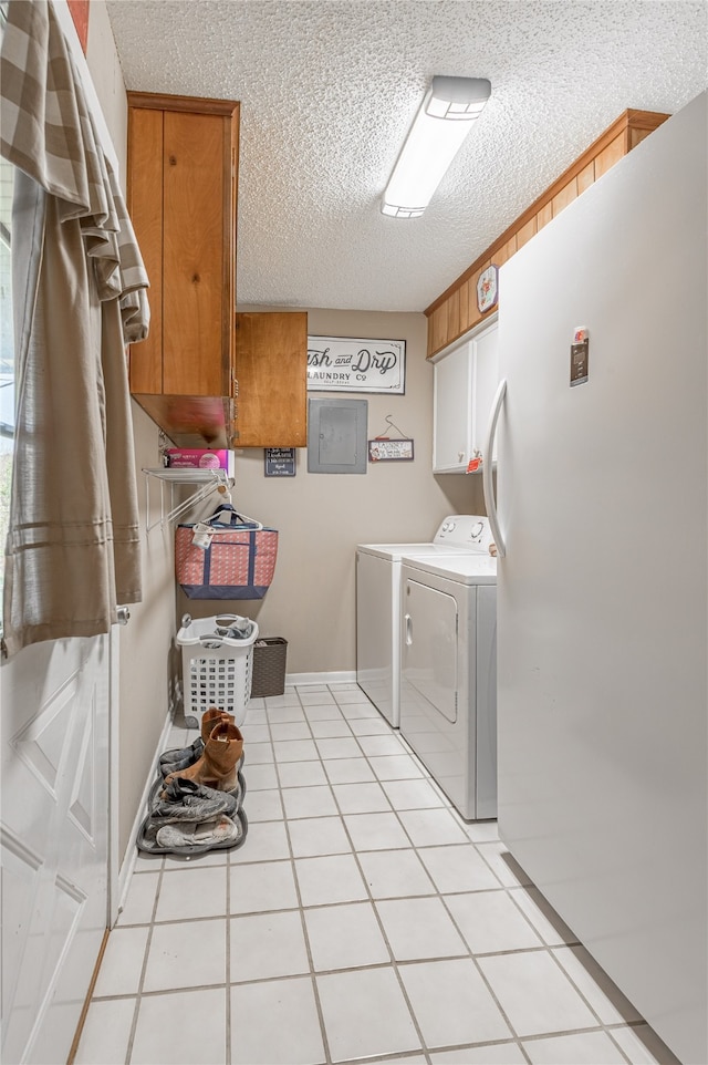 laundry area with cabinets, electric panel, washing machine and dryer, and light tile patterned floors