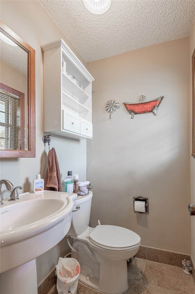 bathroom with sink, a textured ceiling, and toilet