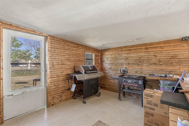 miscellaneous room featuring a textured ceiling and wood walls