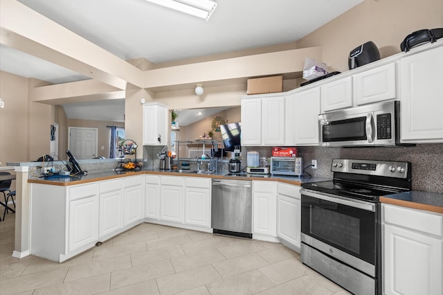 kitchen with kitchen peninsula, stainless steel appliances, and white cabinets