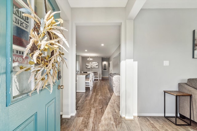 hall featuring a chandelier and hardwood / wood-style flooring