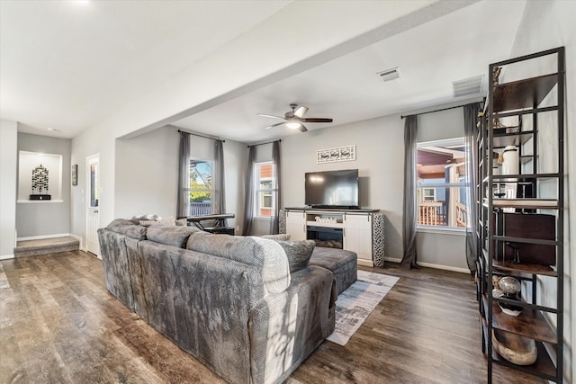 living room featuring ceiling fan, a fireplace, and dark hardwood / wood-style floors