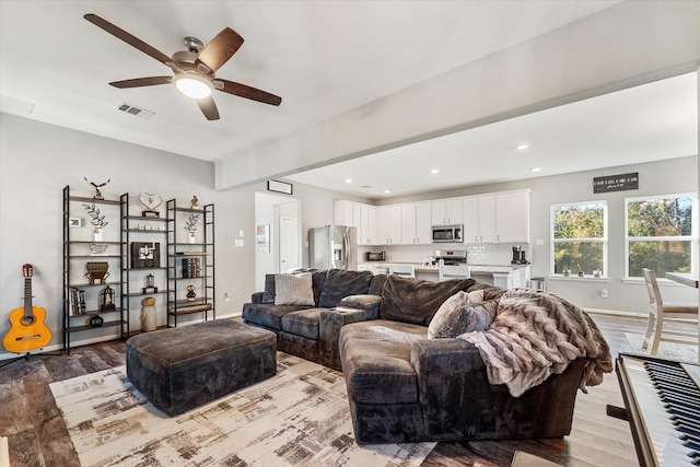 living room with ceiling fan and light wood-type flooring