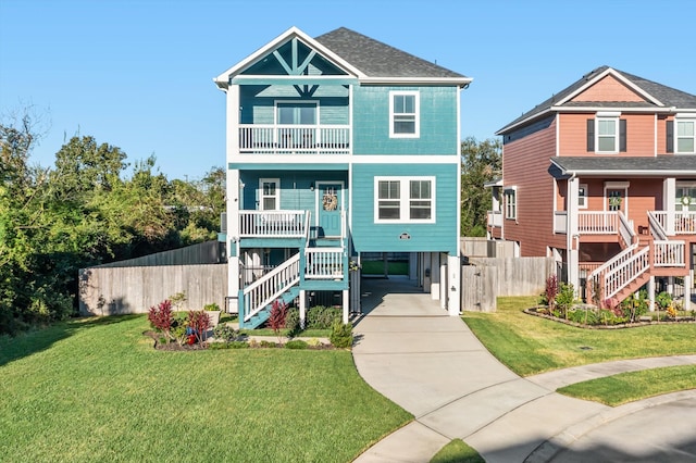 beach home with a balcony, a front yard, a porch, and a carport