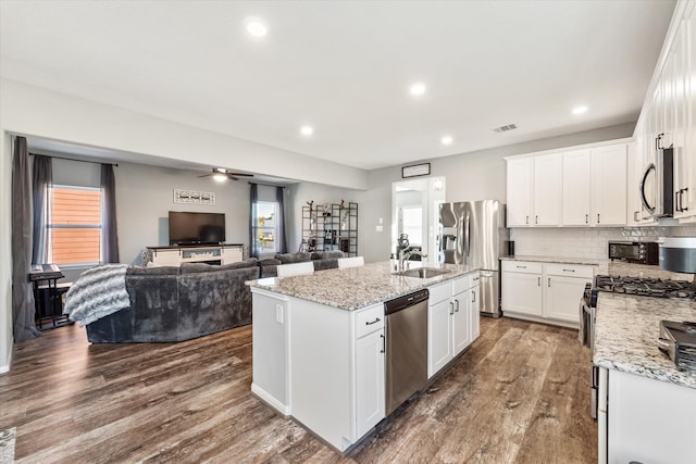 kitchen with dark hardwood / wood-style flooring, stainless steel appliances, white cabinetry, and a wealth of natural light