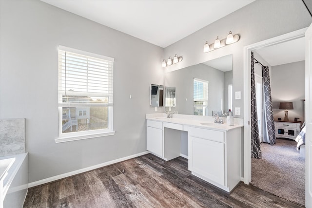 bathroom featuring a washtub, vanity, and hardwood / wood-style flooring