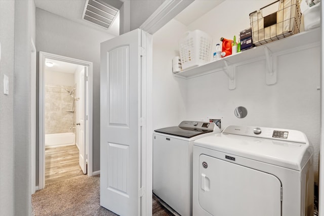 clothes washing area featuring independent washer and dryer and hardwood / wood-style floors