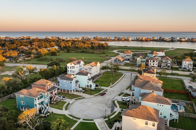 aerial view at dusk featuring a water view