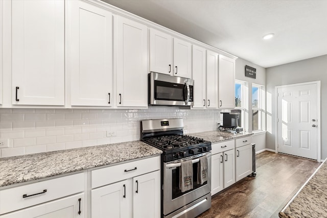 kitchen featuring decorative backsplash, dark hardwood / wood-style flooring, white cabinetry, and stainless steel appliances