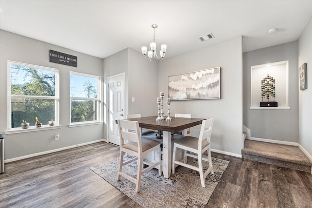 dining area with dark hardwood / wood-style flooring and a chandelier