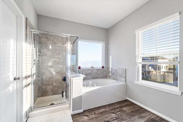 bathroom featuring hardwood / wood-style flooring, separate shower and tub, and a wealth of natural light