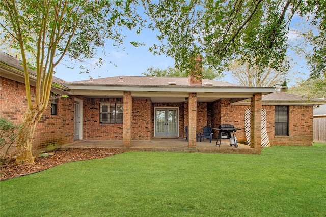 rear view of house with a yard and a patio