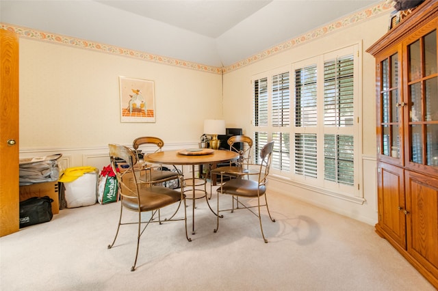 carpeted dining space featuring vaulted ceiling