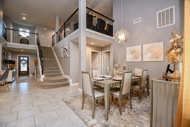 tiled dining room featuring a high ceiling and a notable chandelier