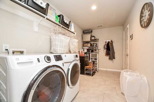 laundry area with separate washer and dryer and light tile patterned floors