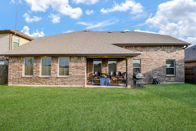 rear view of house featuring a yard and a patio