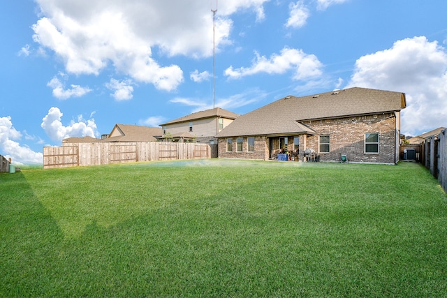 rear view of property with a yard