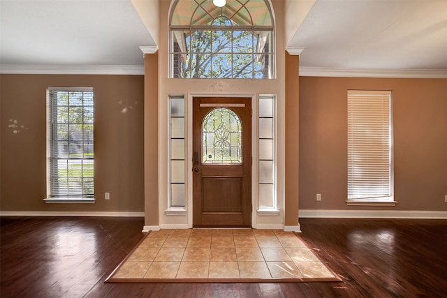 entryway with light hardwood / wood-style floors and crown molding