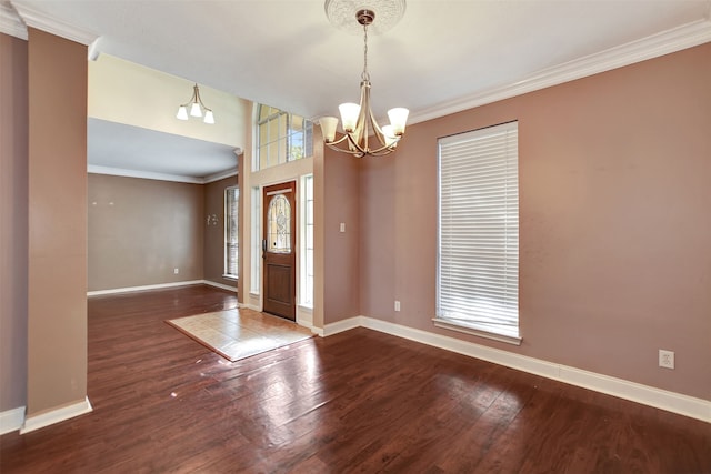 foyer entrance featuring a notable chandelier, dark hardwood / wood-style floors, and crown molding