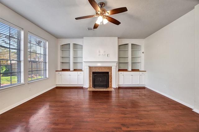 unfurnished living room with a fireplace, dark hardwood / wood-style floors, and ceiling fan