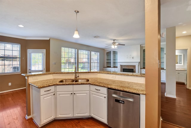 kitchen featuring dark hardwood / wood-style flooring, stainless steel dishwasher, light stone counters, pendant lighting, and white cabinets