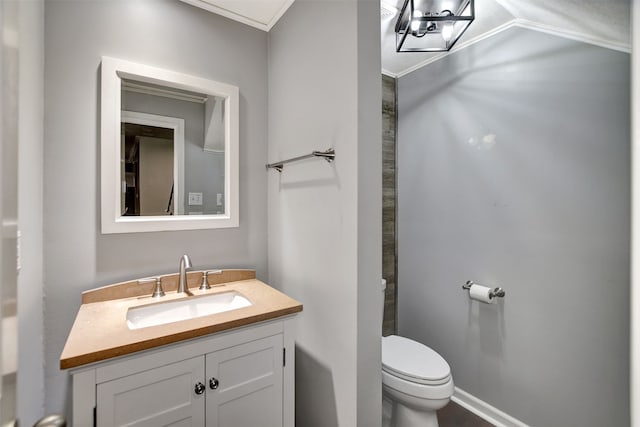 bathroom with vanity, toilet, and ornamental molding