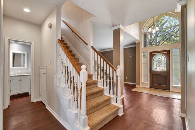 entrance foyer with a wealth of natural light, hardwood / wood-style floors, an inviting chandelier, and sink