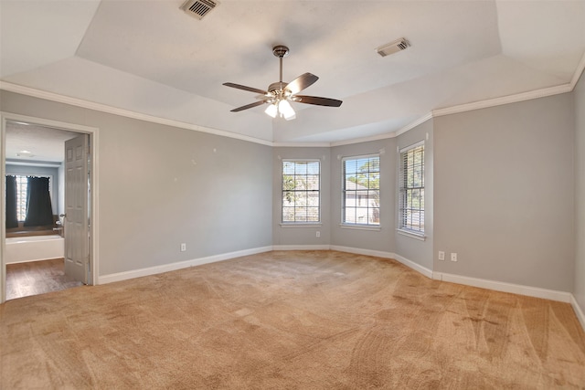 carpeted spare room featuring ceiling fan, crown molding, and a tray ceiling