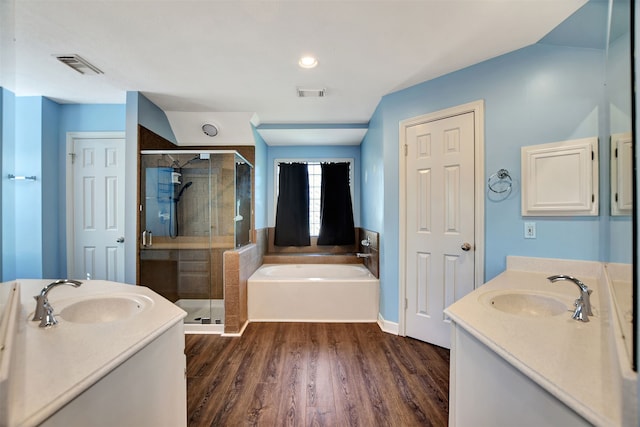 bathroom featuring wood-type flooring, vanity, and shower with separate bathtub