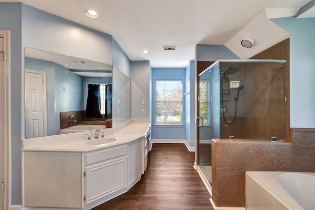 bathroom featuring hardwood / wood-style floors, vanity, and shower with separate bathtub